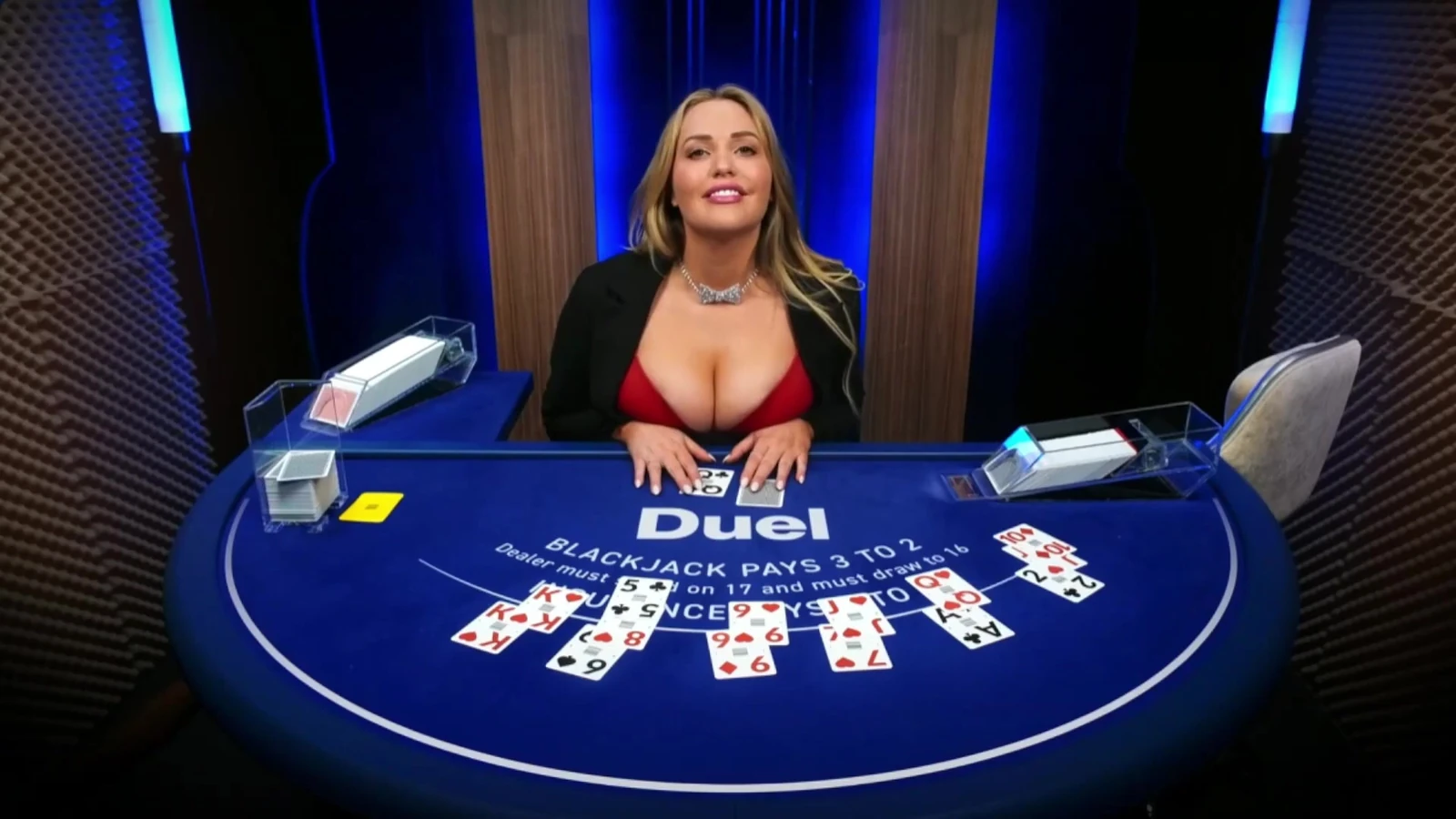 Mia Malkova seated behind a blue Duel-branded live blackjack table
